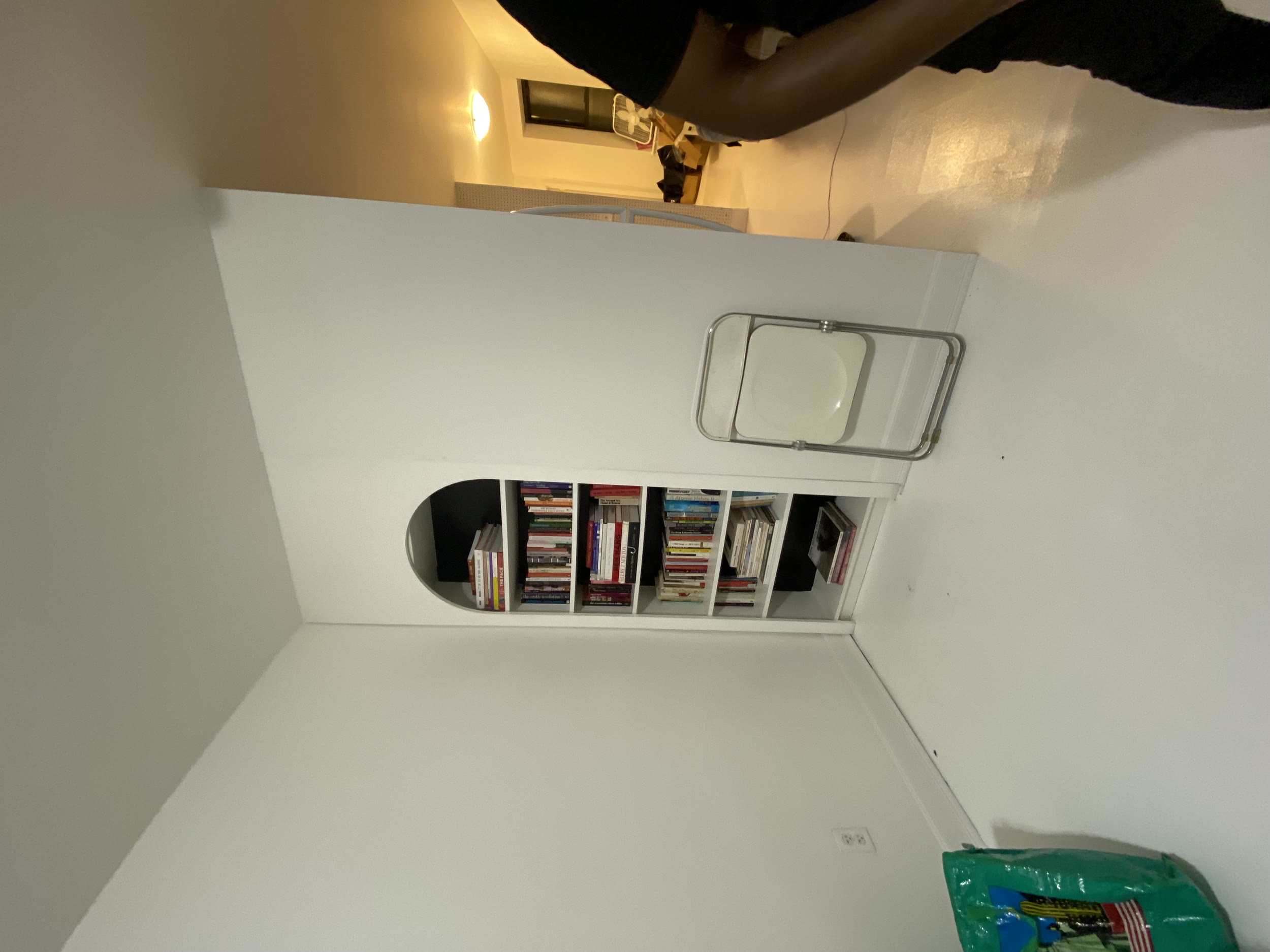 Custom built-in bookshelf with arched fascia and concealed false wall behind it, installed by Jose Does It.